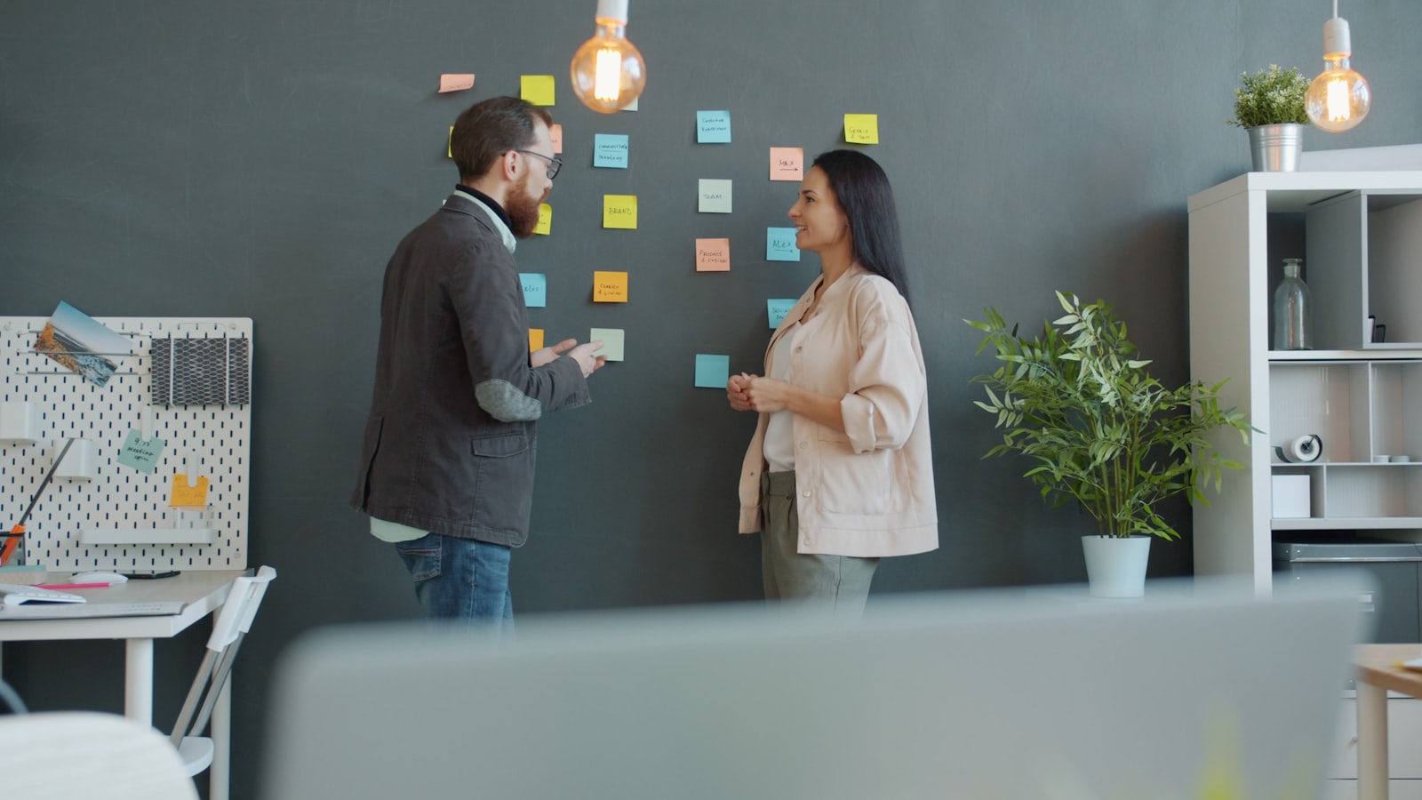 Colleagues brainstorming with sticky notes on a wall